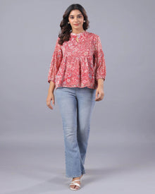 Woman in a pink floral top with light blue jeans and white sandals, Western wear style