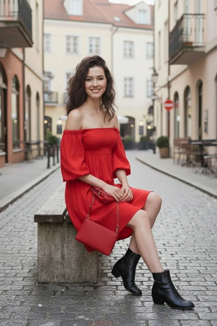 Red off-shoulder mini dress for women featuring smocked design | Model in sitting pose 
