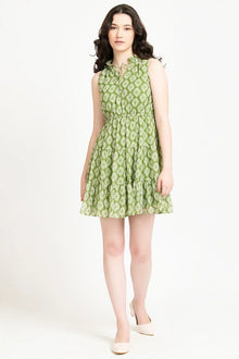 Woman in sleeveless green printed western dress with flared skirt, standing indoors