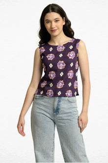 Woman in sleeveless purple floral print western top and light blue jeans