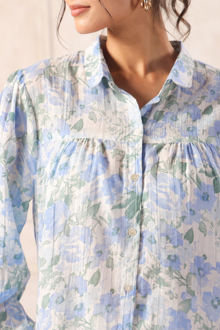 Woman wearing blue floral print Western shirt with button front and ruffled collar