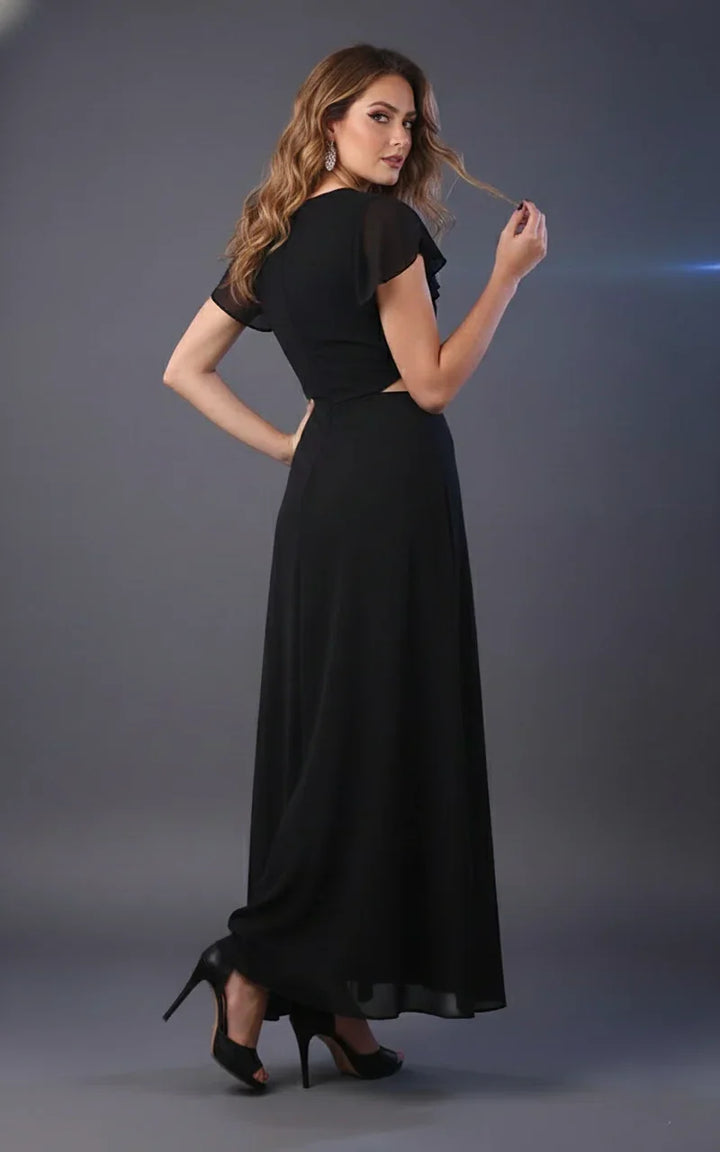 Woman wearing black maxi dress with short flutter sleeves and heels, posing in studio