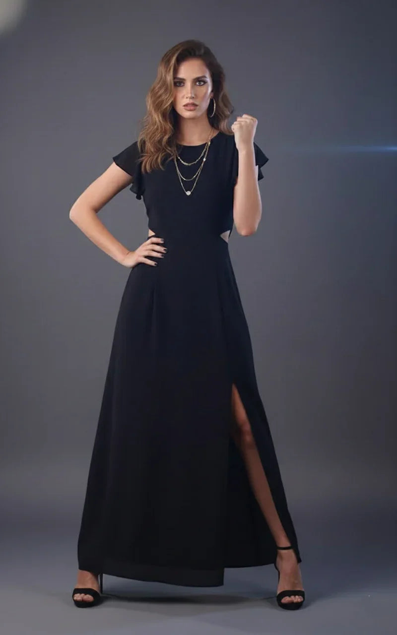 Woman wearing a black maxi dress with side slit, short sleeves, and layered necklaces