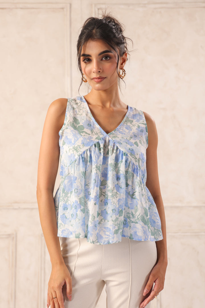 Woman wearing a floral sleeveless top against a plain background