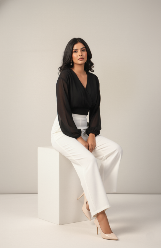 Woman wearing black chiffon crop top with long sleeves and white high-waist pants