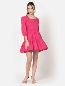 Side view of fuschia mini dress for women showing puffed sleeves and flared skirt.