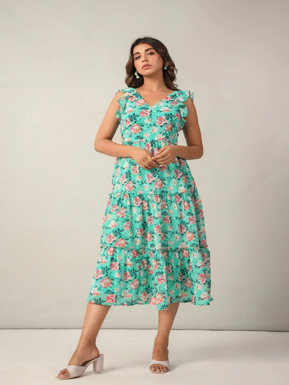 Woman wearing mint green fit and flare midi dress with floral print and ruffle sleeves