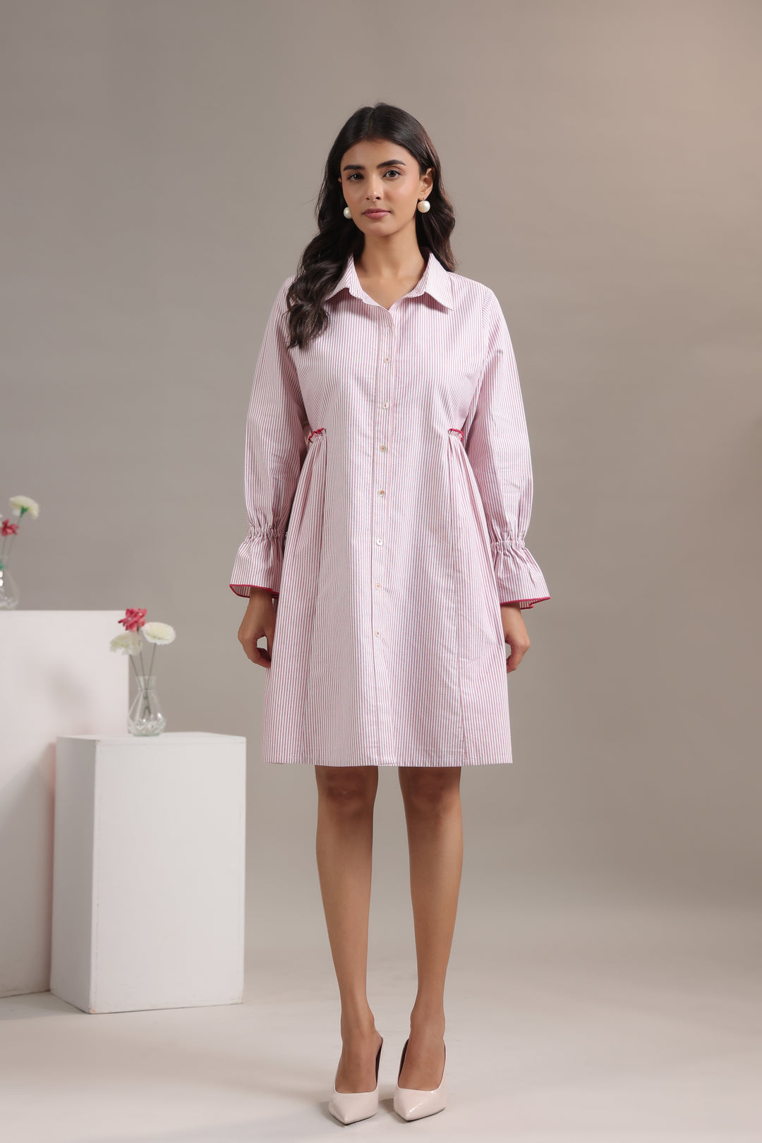 Model wearing a blue and white striped shirt for women with long sleeves and a relaxed fit.