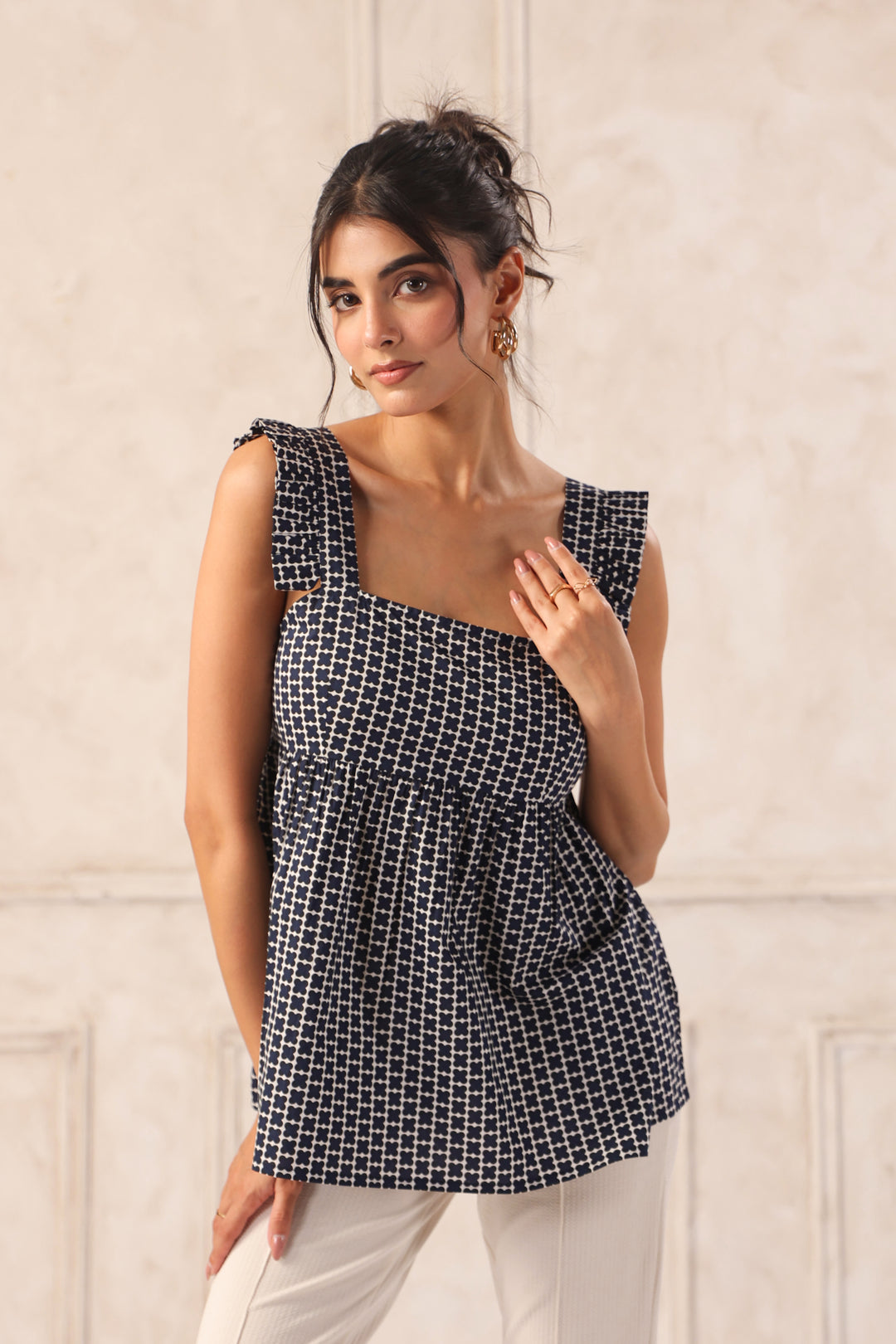Woman wearing a black and white checkered top against a light background