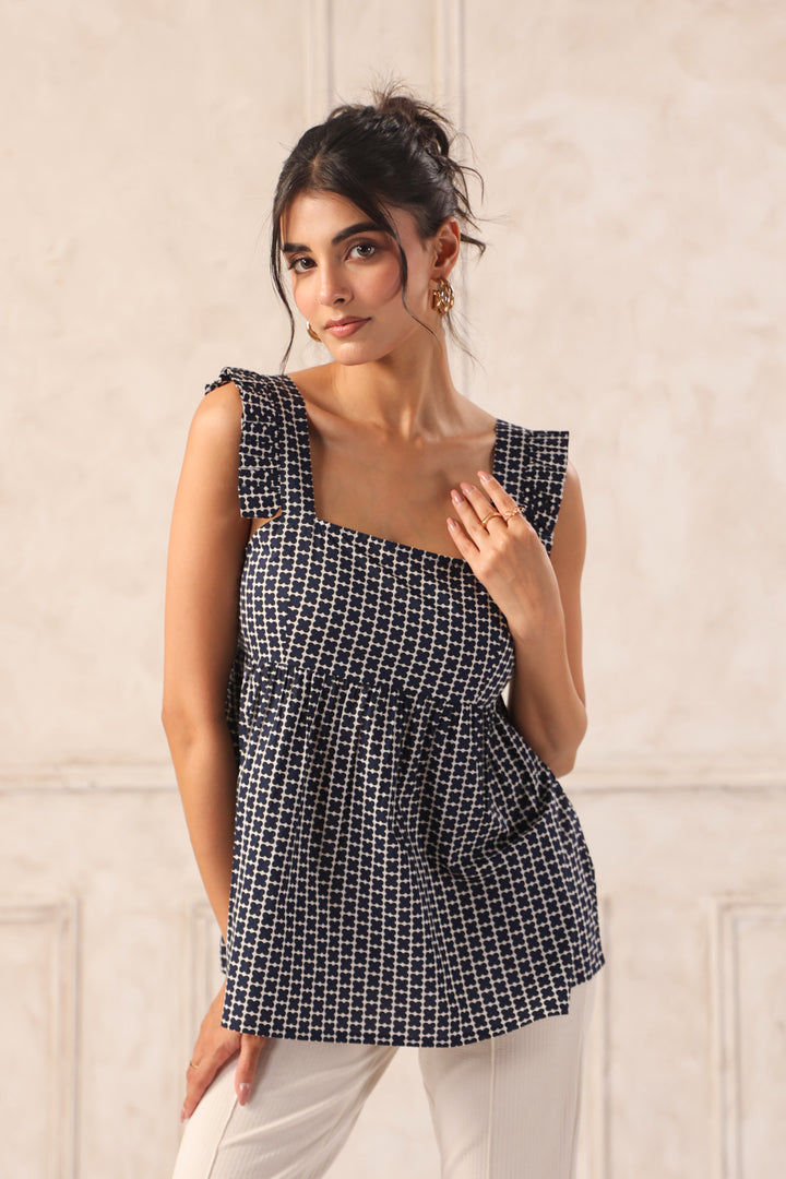 Woman wearing a black and white checkered top against a light background