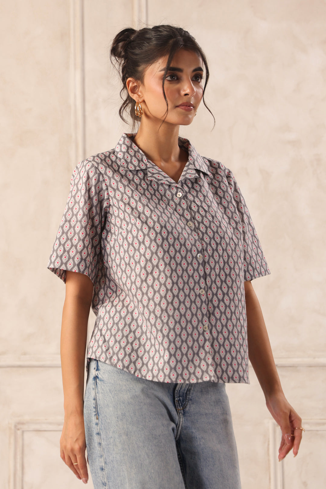 Woman wearing geometric patterned short-sleeve shirt with jeans, chic Western wear top