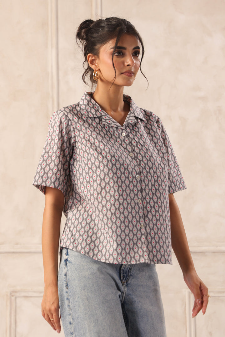 Woman wearing geometric patterned short-sleeve shirt with jeans, chic Western wear top