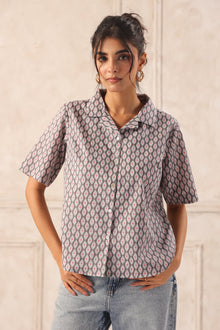 Woman modeling a gray patterned button-up shirt with short sleeves, paired with jeans, for Western wear fashion.