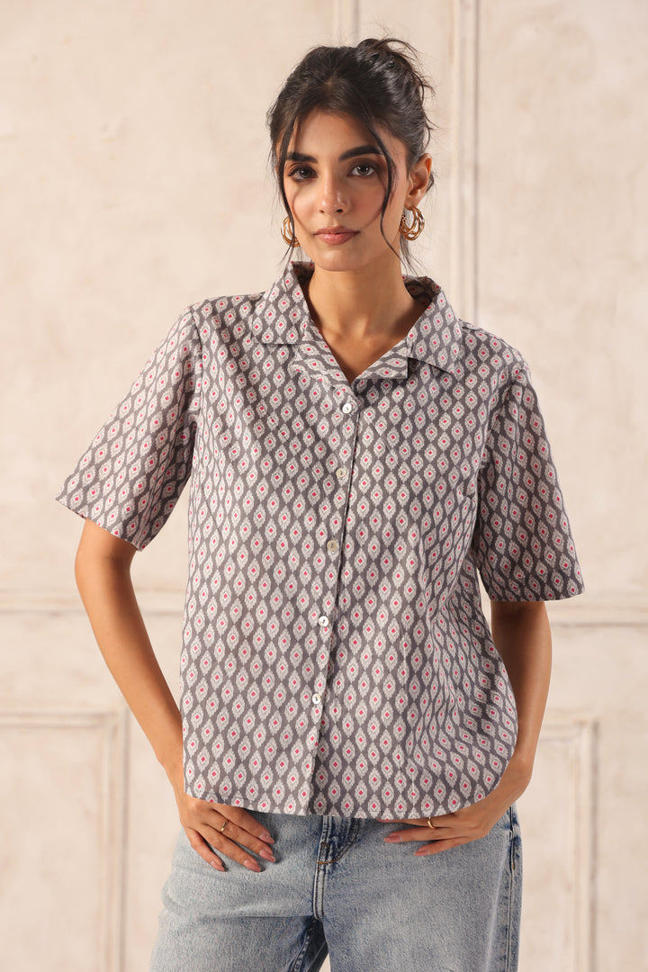 Woman modeling a gray patterned button-up shirt with short sleeves, paired with jeans, for Western wear fashion.