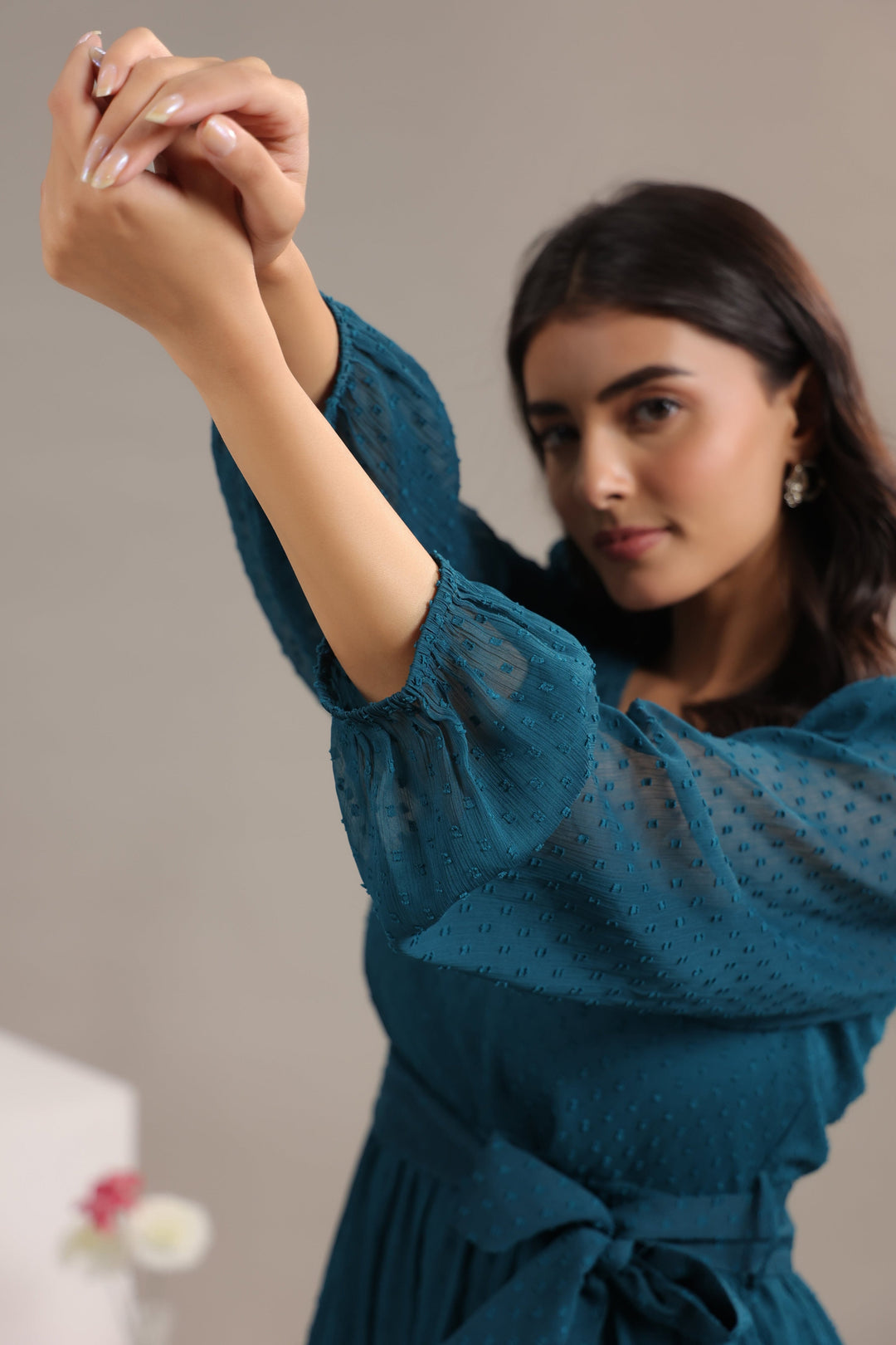 Woman wearing a teal dress with a blurred background