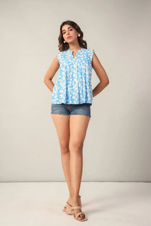 Woman wearing blue floral sleeveless top and denim shorts, Western wear fashion