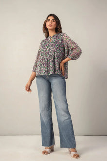 Woman in a floral print western top with balloon sleeves and blue flared jeans