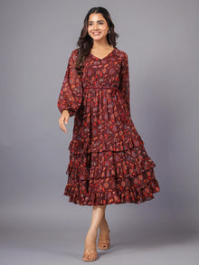 Woman wearing a maroon floral print tiered midi dress with long sleeves and ruffle details