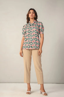 Woman wearing a floral print short-sleeve top with beige straight-leg pants and heels