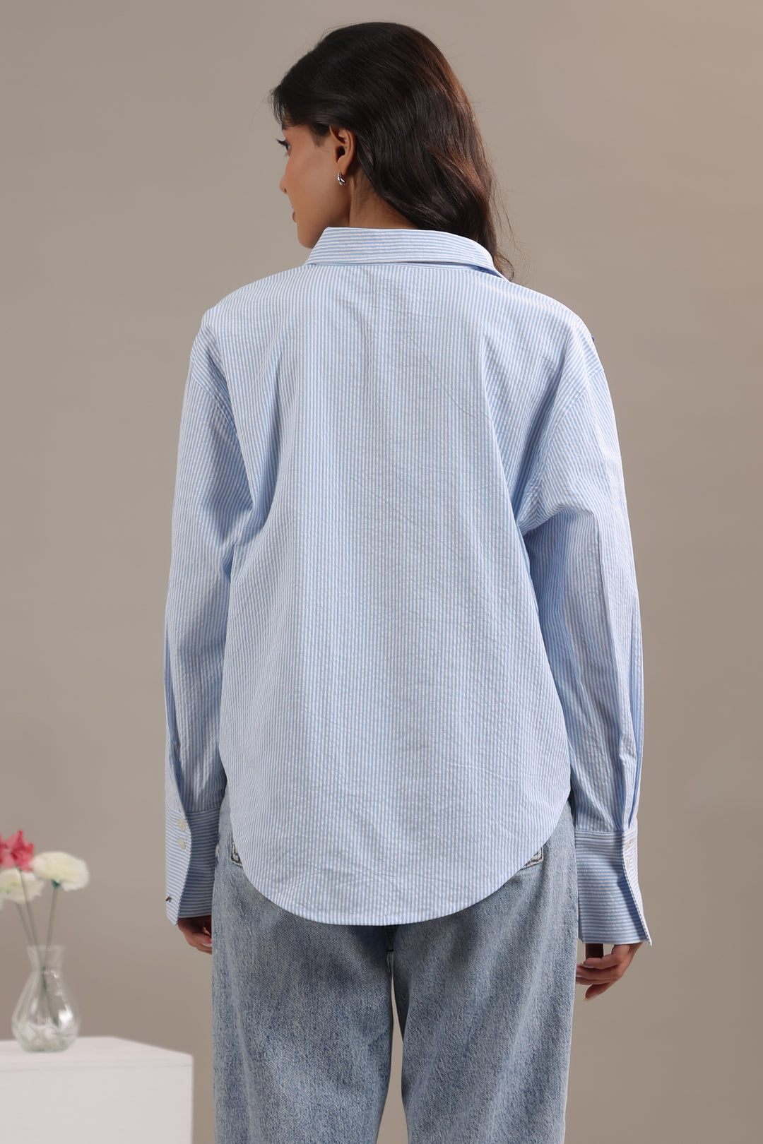 Back view of blue and white striped shirt women showing asymmetric hem design