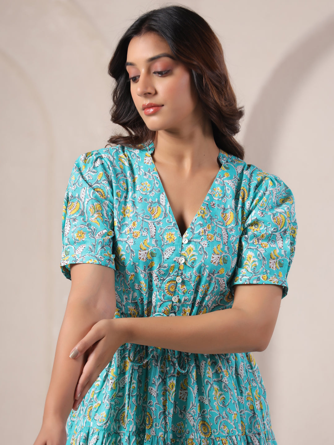 Close-up of three-quarter sleeves and paisley jaal print on sky blue cotton dress.
