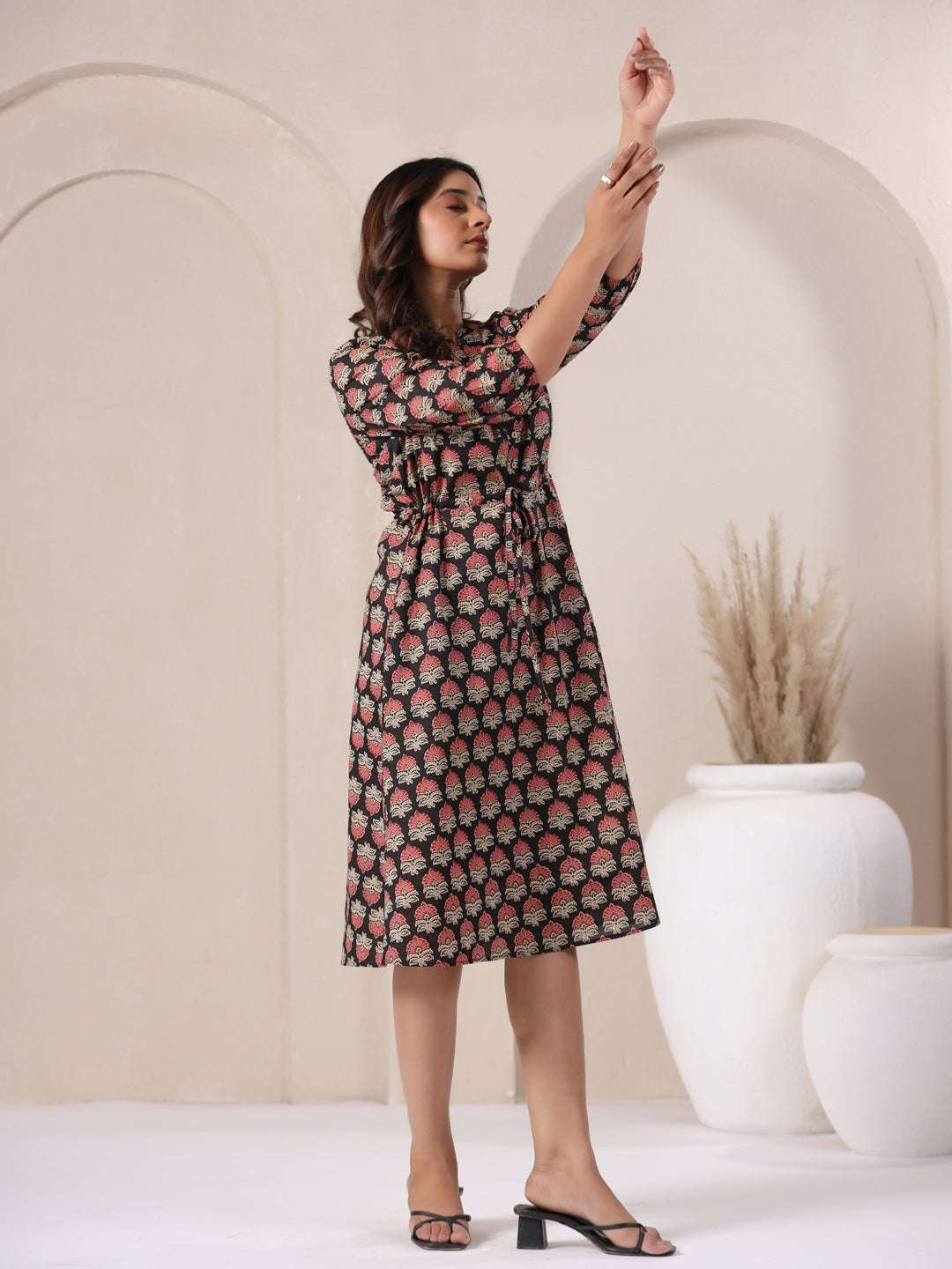 Model wearing sustainable black Ajrakh cotton midi dress, eco-friendly fashion.